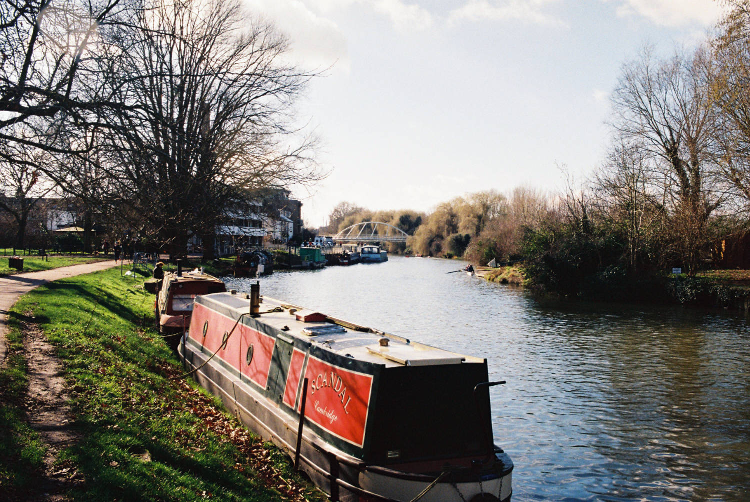 Houseboat named 'Scandal' on the River Cam, with Equiano bridge visible.