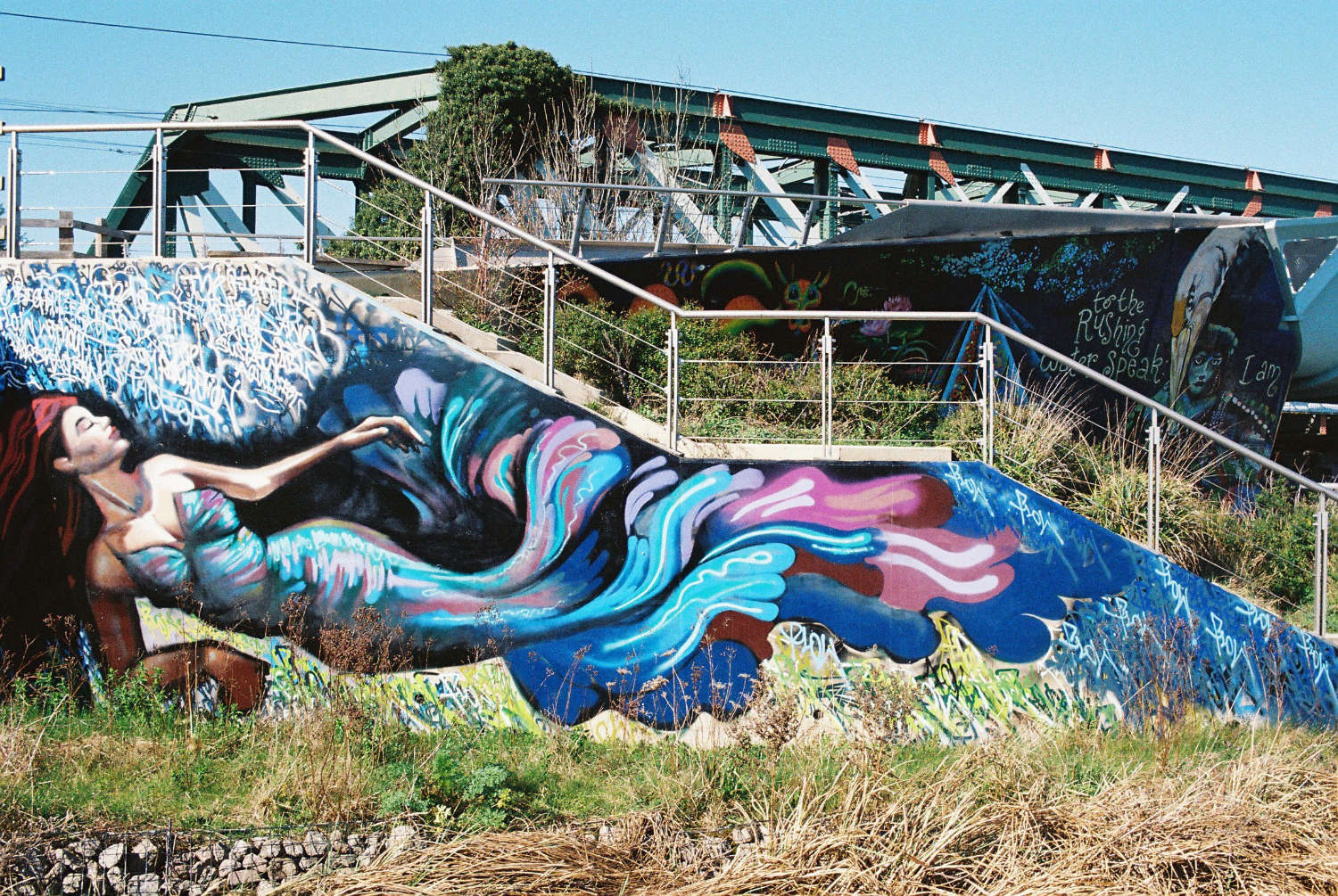 Mural on stairs leading to Chisholm Trail bridge.
