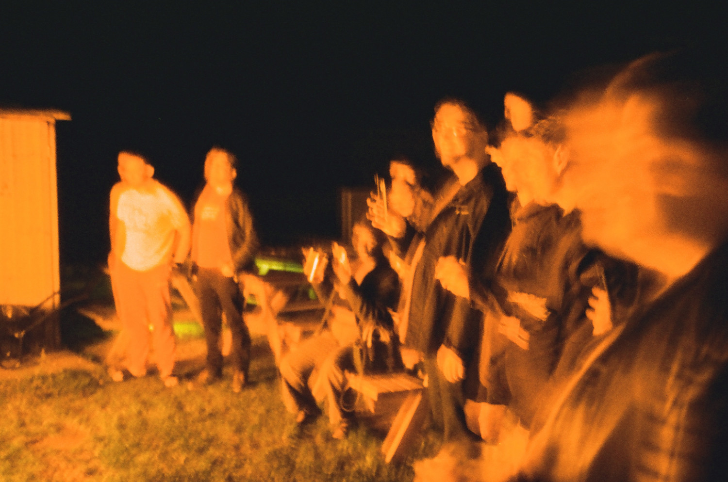 Crowd illuminated by light of a burning Christmas tree.